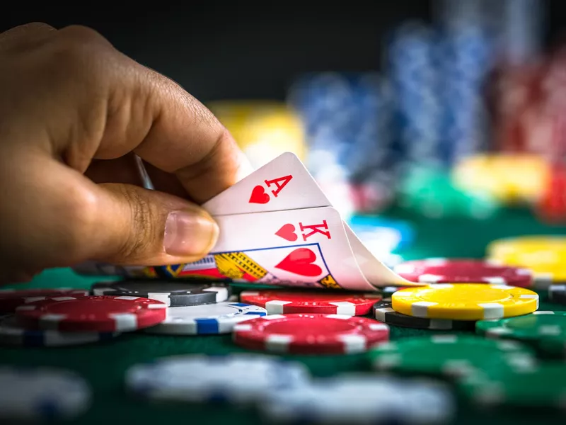 Gambling hand holding poker cards and chips