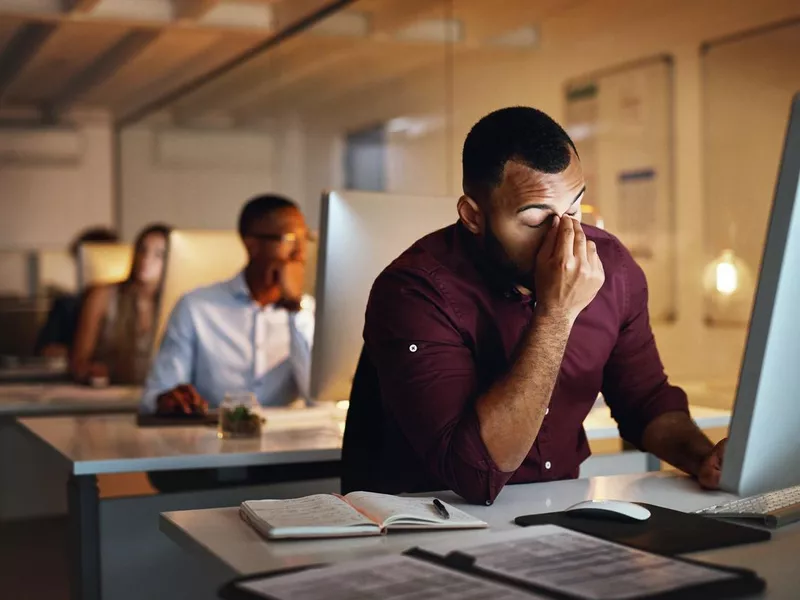 A young businessman stressed at work