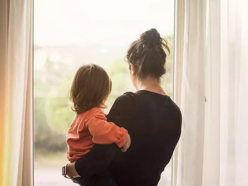 Mother and son looking out of window