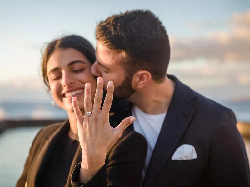 Happy woman displaying her engagement ring from loving fiancé