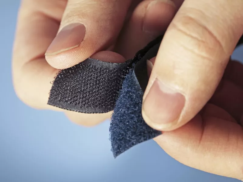 Pair of hands holding two sides of Velcro