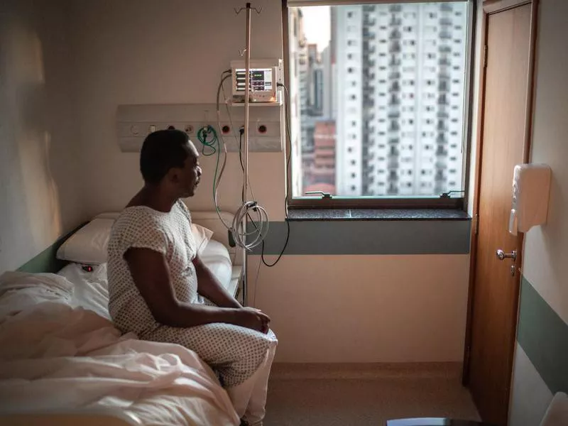 Senior patient looking through window at hospital