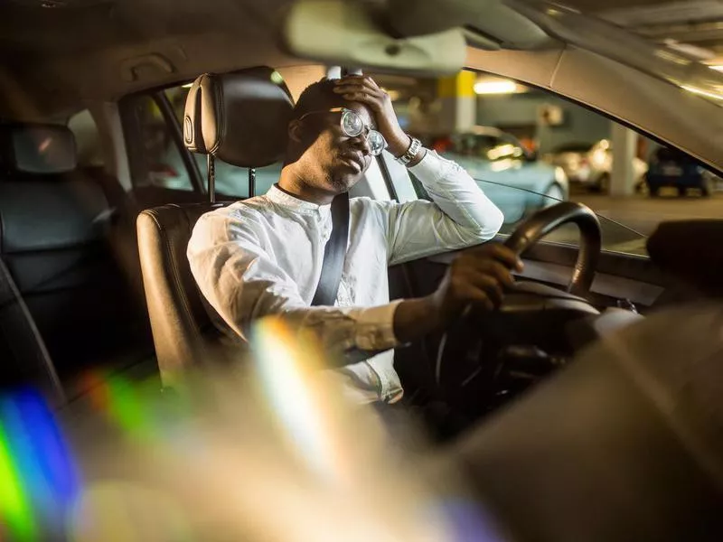 Exhausted businessman driving a car