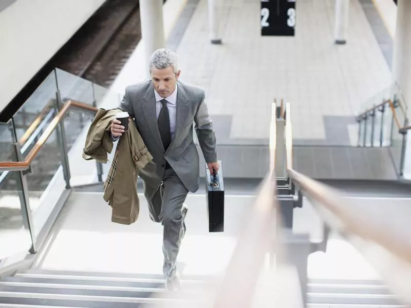 Businessman walking up stairs in train station