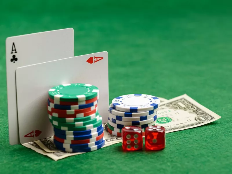 Casino green table with playing cards, chips, money and dices