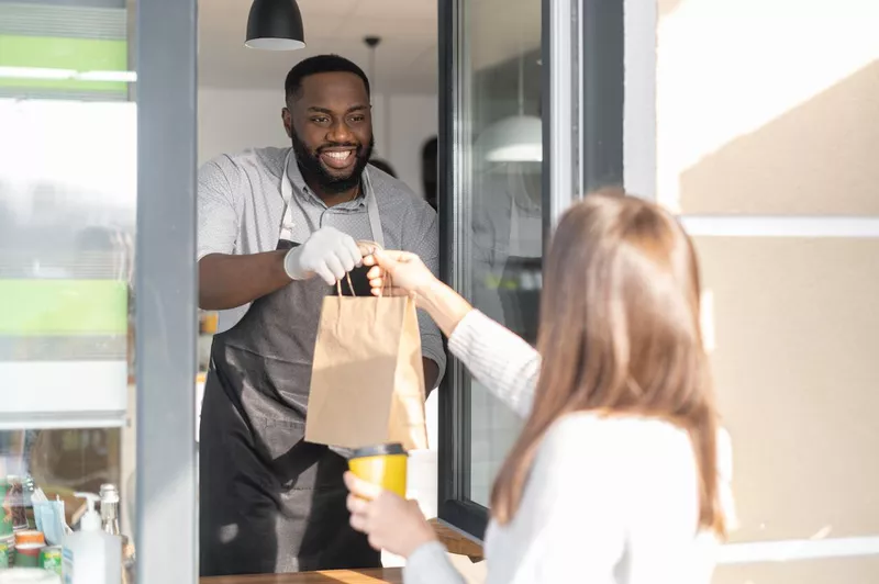 A restaurant worker is serving a guest