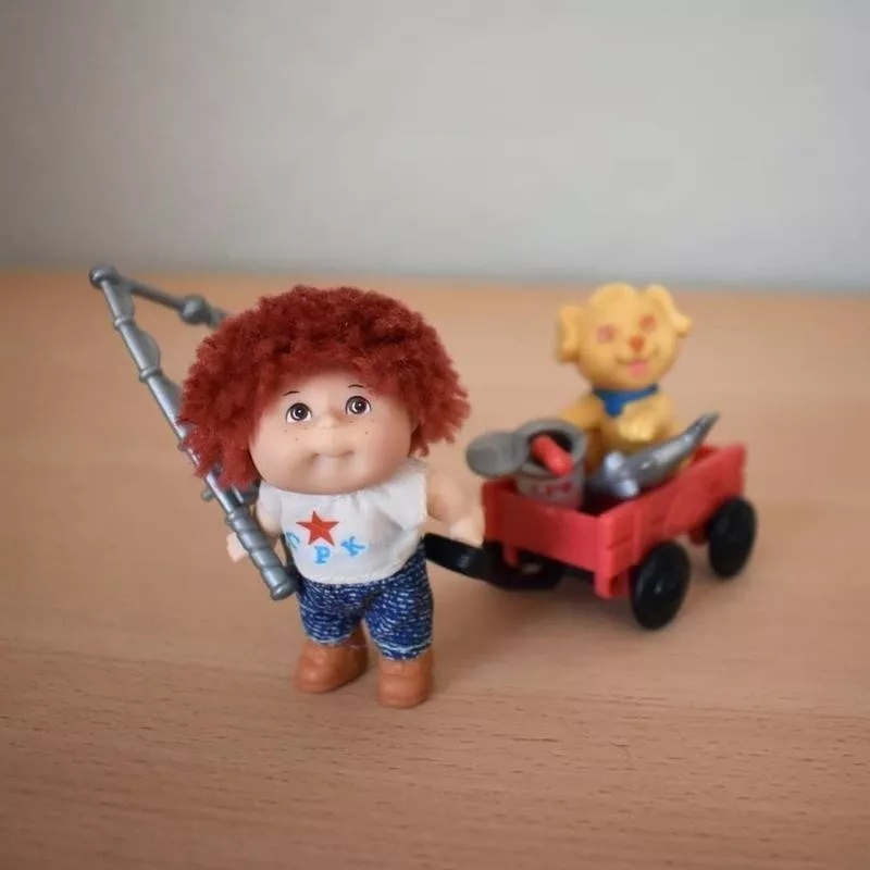 Cabbage Patch Kids mini carrying a wagon with a dog