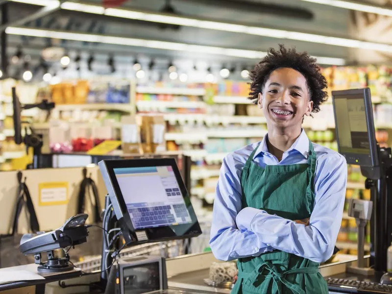 Boy working as supermarket cashier