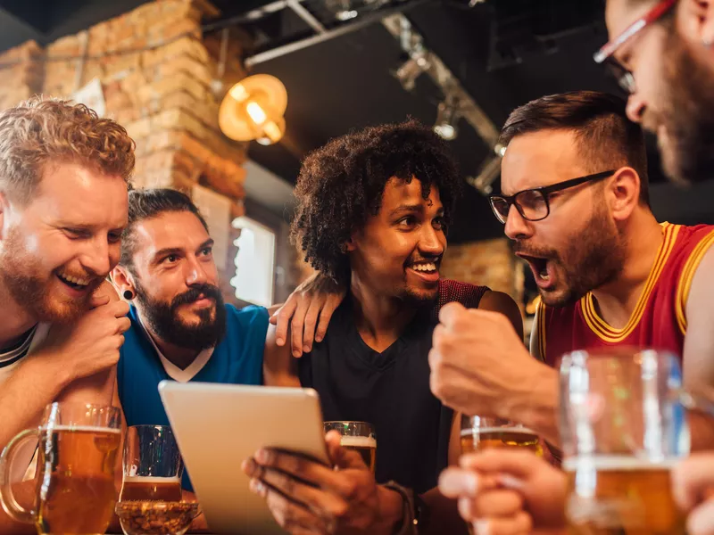 Friends happy while gambling on a tablet