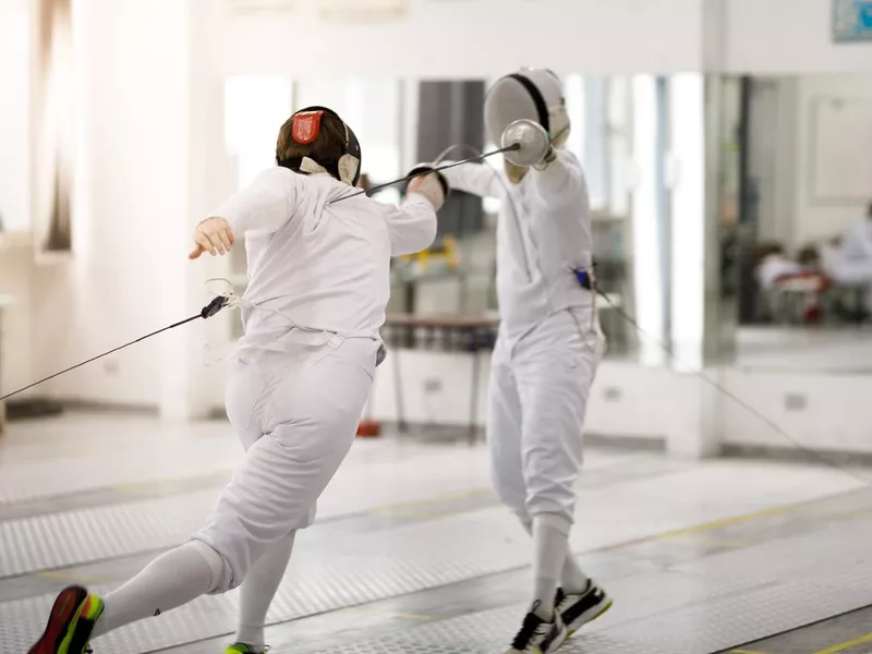 Male fencing athletes playing