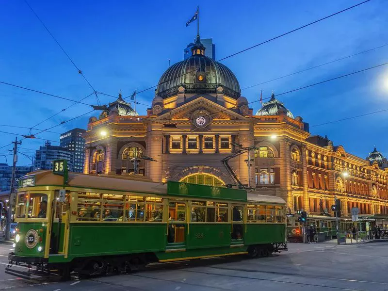 Tram passing Flinders Street Station at dusk