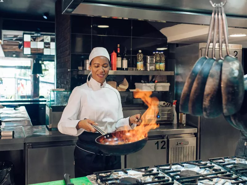 Female chef preparing a flambé specialty