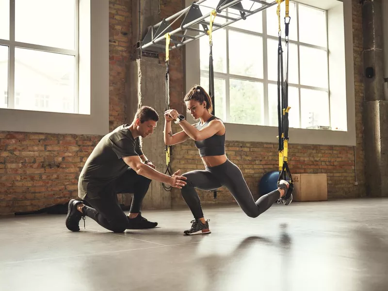 Young personal trainer with athletic woman