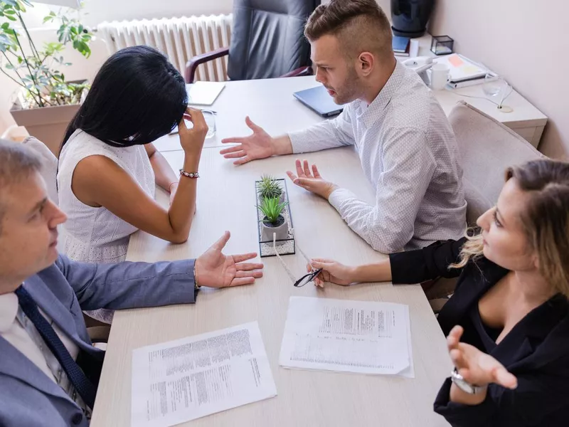 Divorcing couple at the meeting with their lawyers