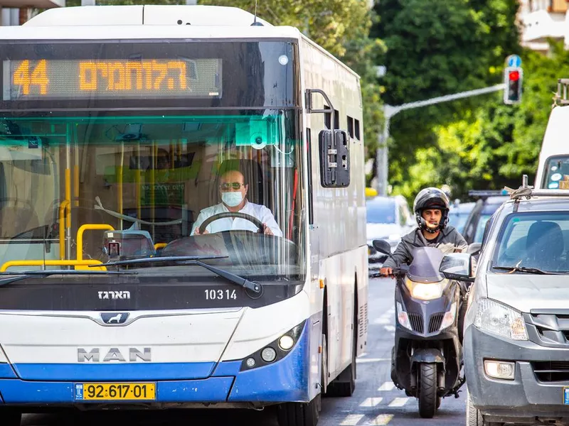 Bus driver driving bus on busy city street