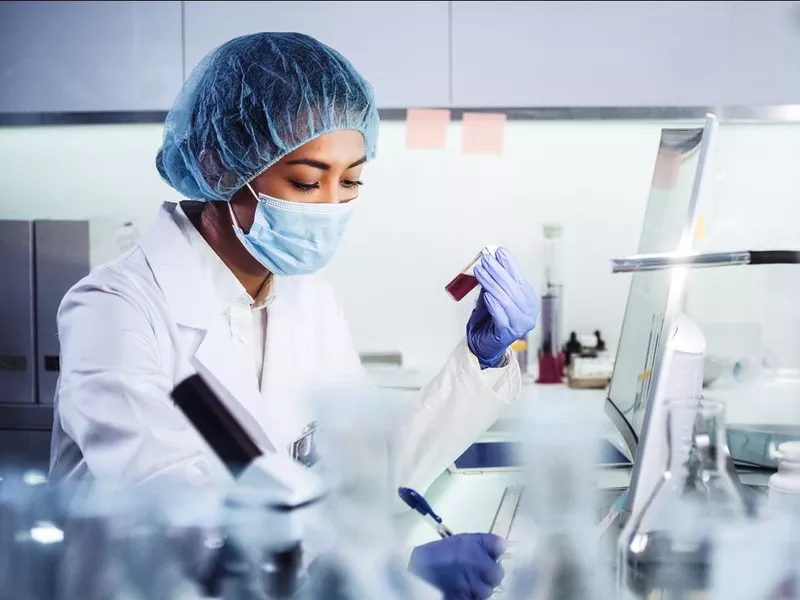 Asian female doctor using microscope and working with pathogen samples