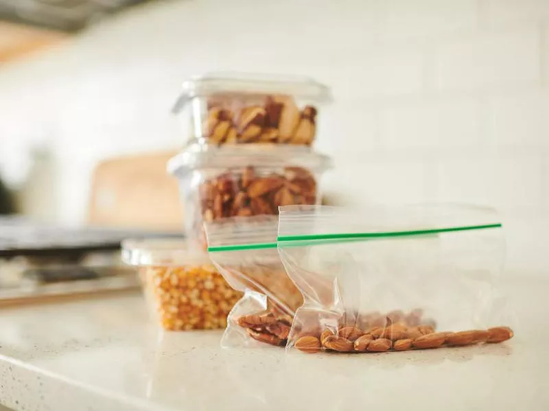 Assorted nuts in plastic containers on a counter in a bright modern kitchen