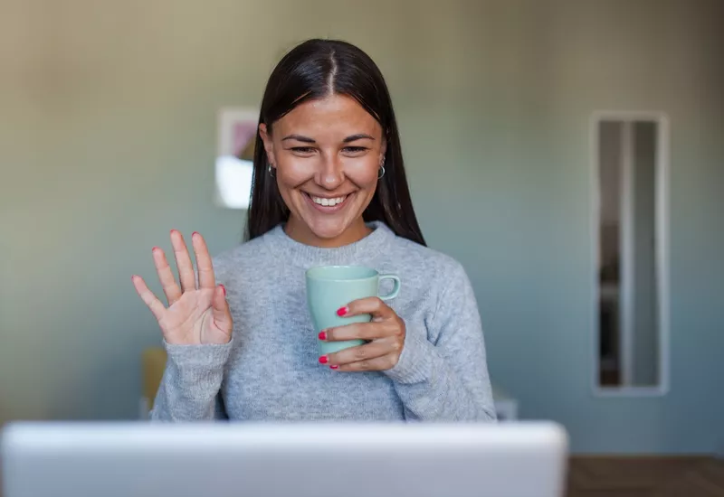 Woman waving at laptop