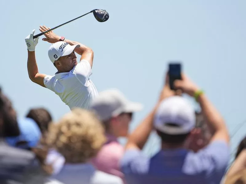 Justin Thomas watches his shot on the ninth tee