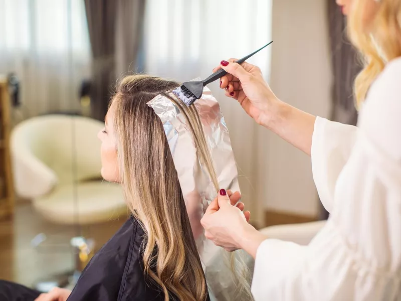 Woman dyeing her hair at the salon