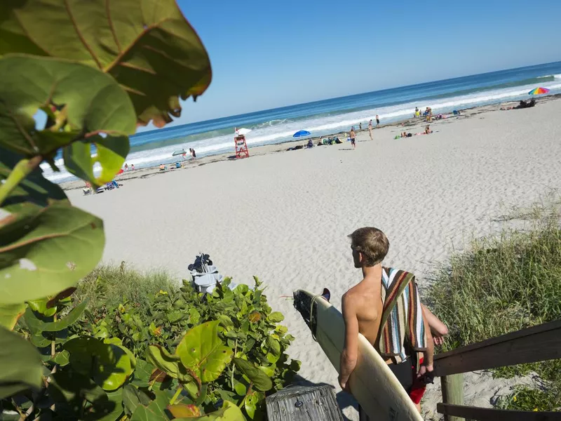 Surfer arriving at the beach