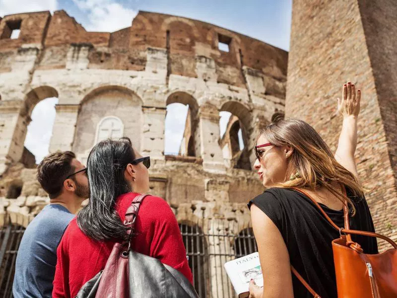 Guide explaining to tourists the Coliseum of Rome