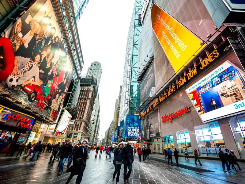 Crowds of tourists exploring Times square during winter holiday