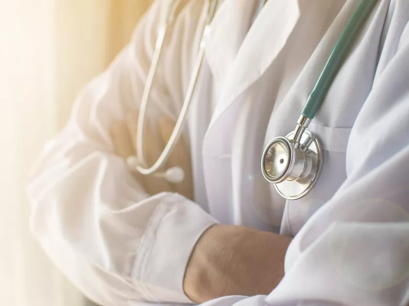 Medical doctor in white gown uniform