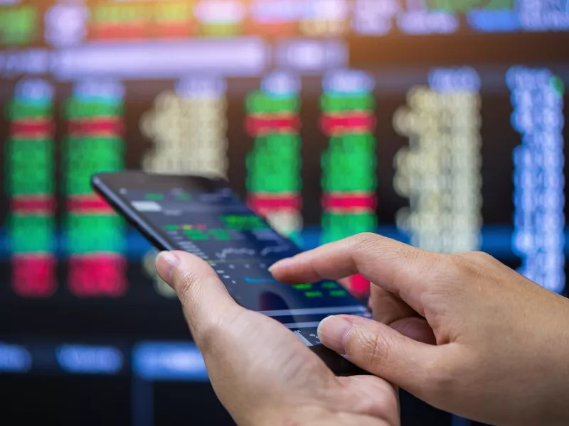 Businessman checking stock market on mobile phone