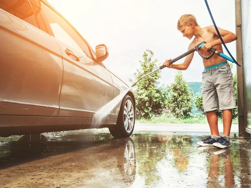 Boy helps to wash a car