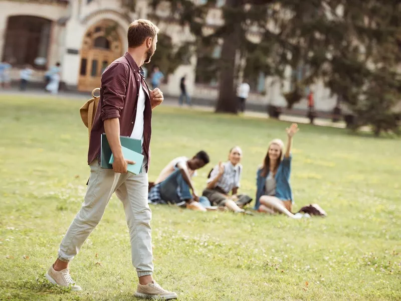 Student with books looking at classmates in the state of Mississippi