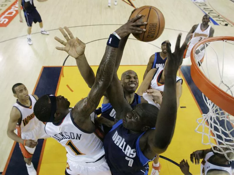 Dallas Mavericks' DeSagna Diop and Jerry Stackhouse fight for rebound