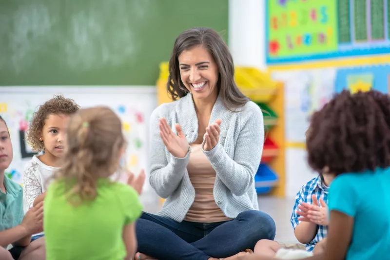 Teacher sitting and teaching students