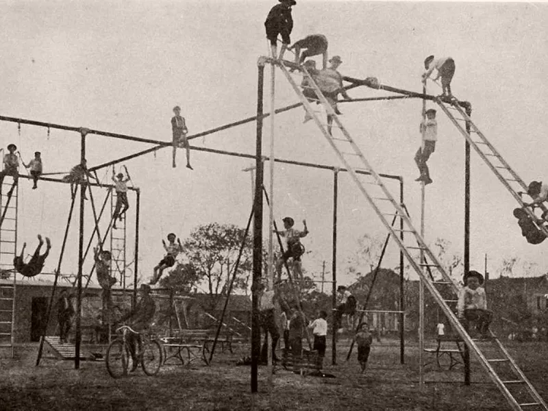 Children climbing on playground equipment in 1900