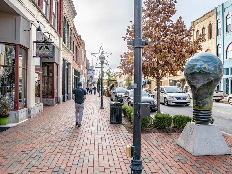 People wander Main Street area past Misty Morning sculpture