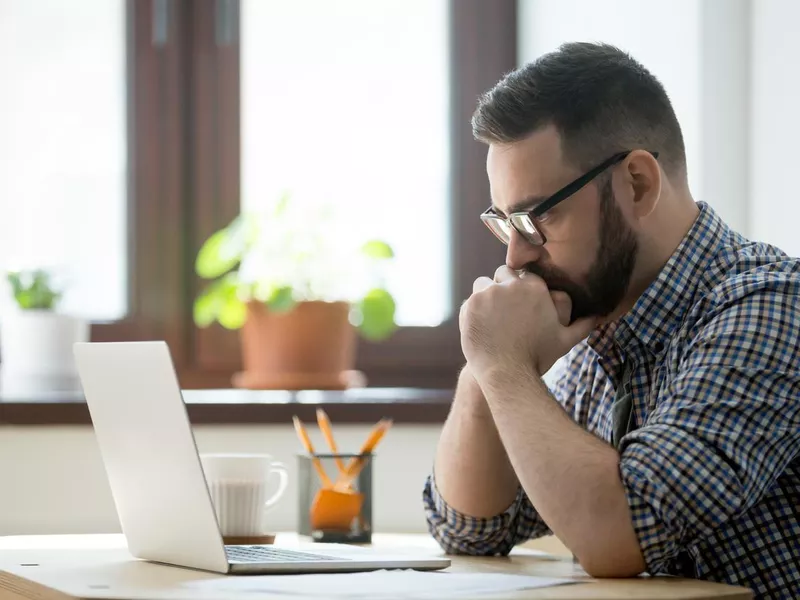 Online moderator looking at laptop