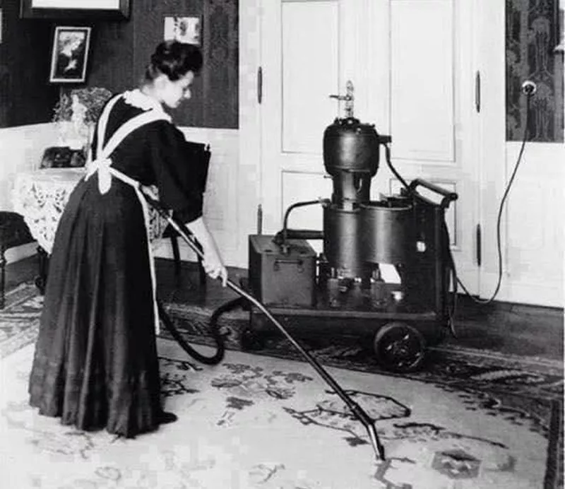 Woman vacuuming in the early 1900s