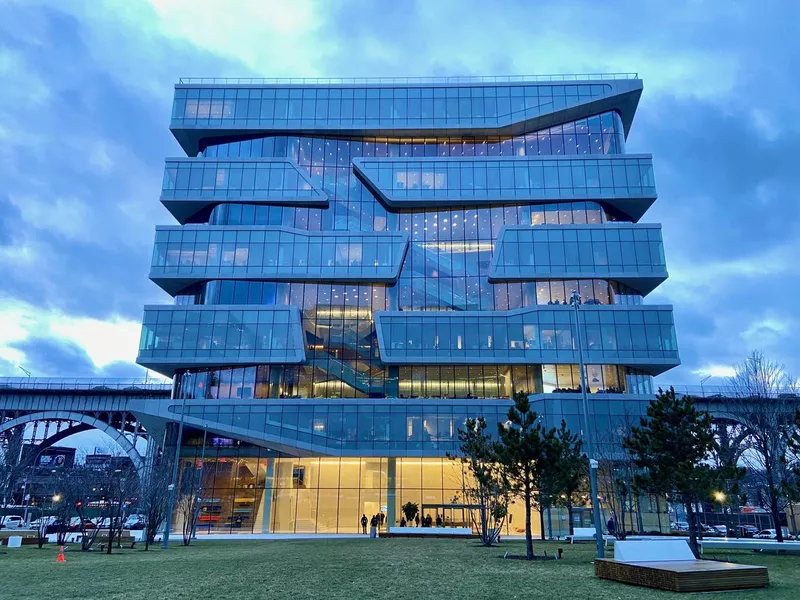 Columbia Business School's Henry Kravis Hall in Manhattanville, New York City, lit up at dusk